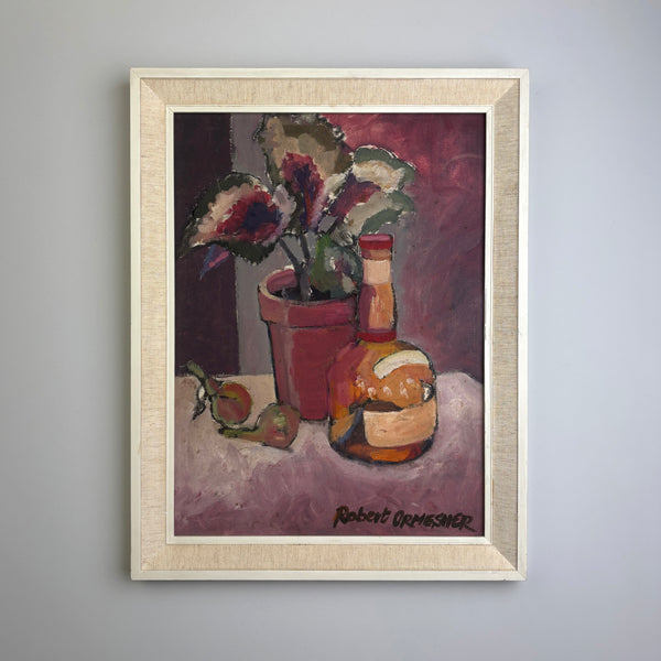 A framed vintage mid century still life oil painting on a light gray wall. The painting features a potted plant, a bottle, and fruit on a table, signed 'Robert Ormesher' in the bottom right corner. Beautiful plum and pink colours. 