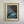 A MCM mid century modern framed portrait painting of a Black woman with an afro hairstyle, wearing a light blue collar and dark blue dress, set in a distressed gold frame and hanging on a light gray wall. VIntage art in good condition 
